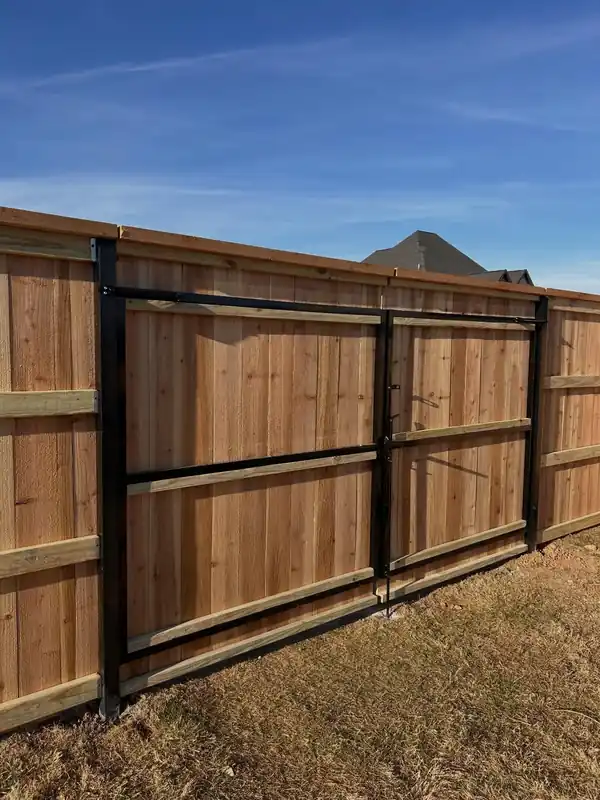 Cedar privacy fence with a black-framed double drive gate