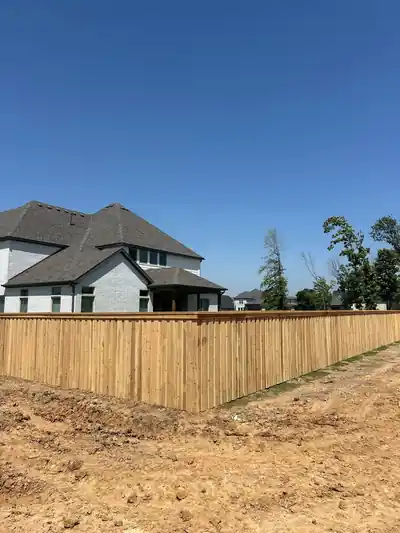 Cedar privacy fence around a new-build backyard with a two-storey house behind