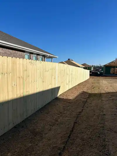 Pine privacy fence running down the side yard of a brick ranch house
